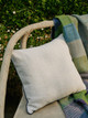 Diet cushion with vertelli piping on a wooden chair alongside Varanasi throw. Photography by Christopher Horwood at Ham Yard Hotel